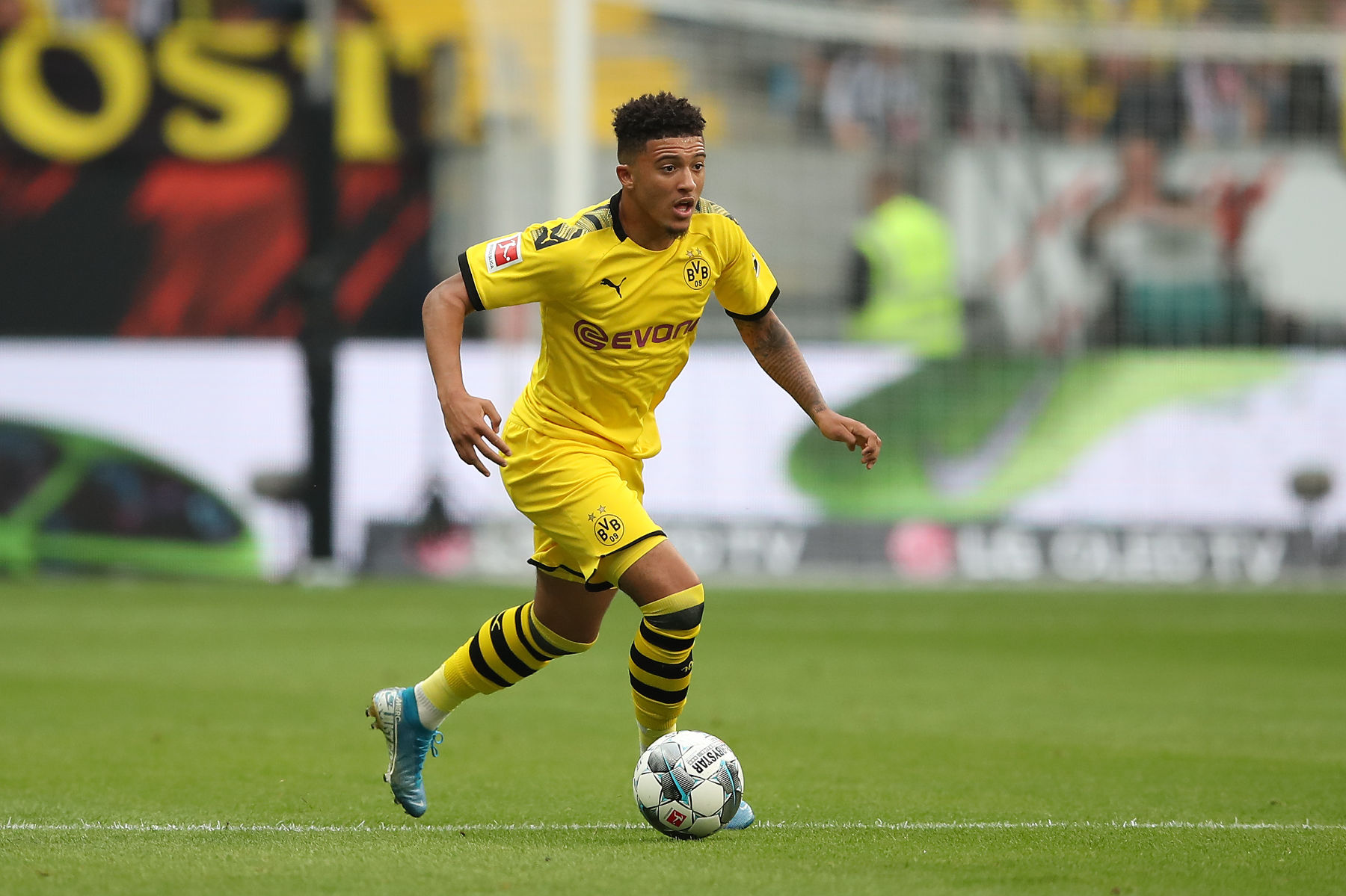  Jadon Sancho dribbles the ball past PSG defenders during a match.